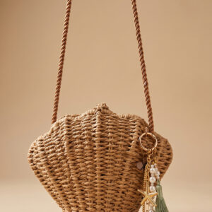 Bolso tejido Isla de Airavata en forma de concha, con correa al hombro y charms decorativos.