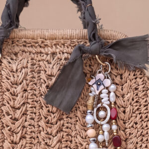 Bolso mini tejido Solé de Airavata con charms decorativos y detalles artesanales.