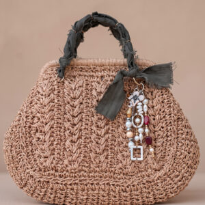 Bolso mini tejido Solé de Airavata con charms decorativos y detalles artesanales.