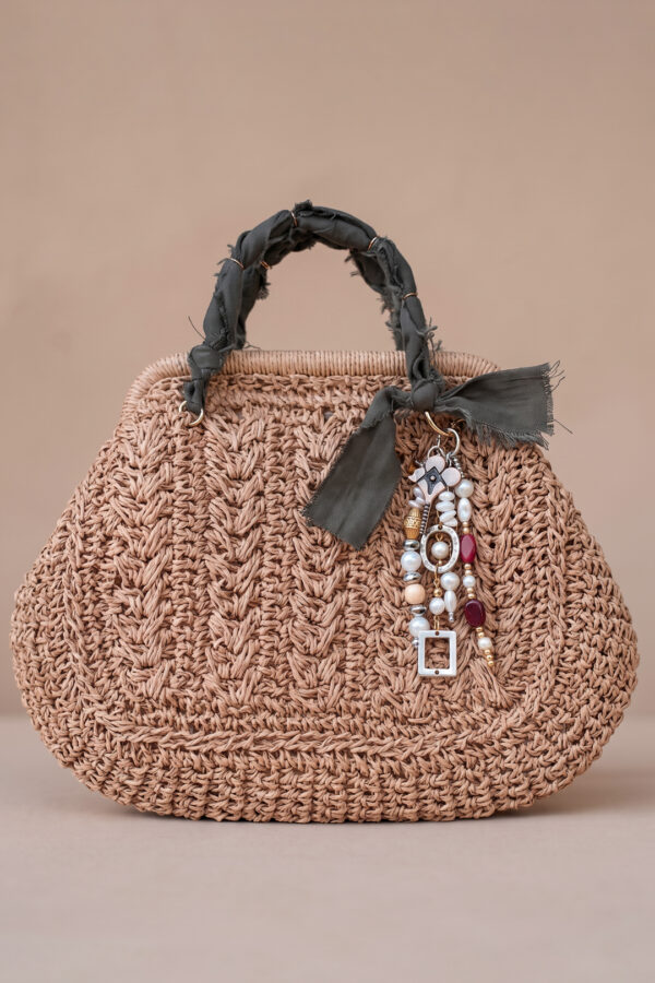 Bolso mini tejido Solé de Airavata con charms decorativos y detalles artesanales.